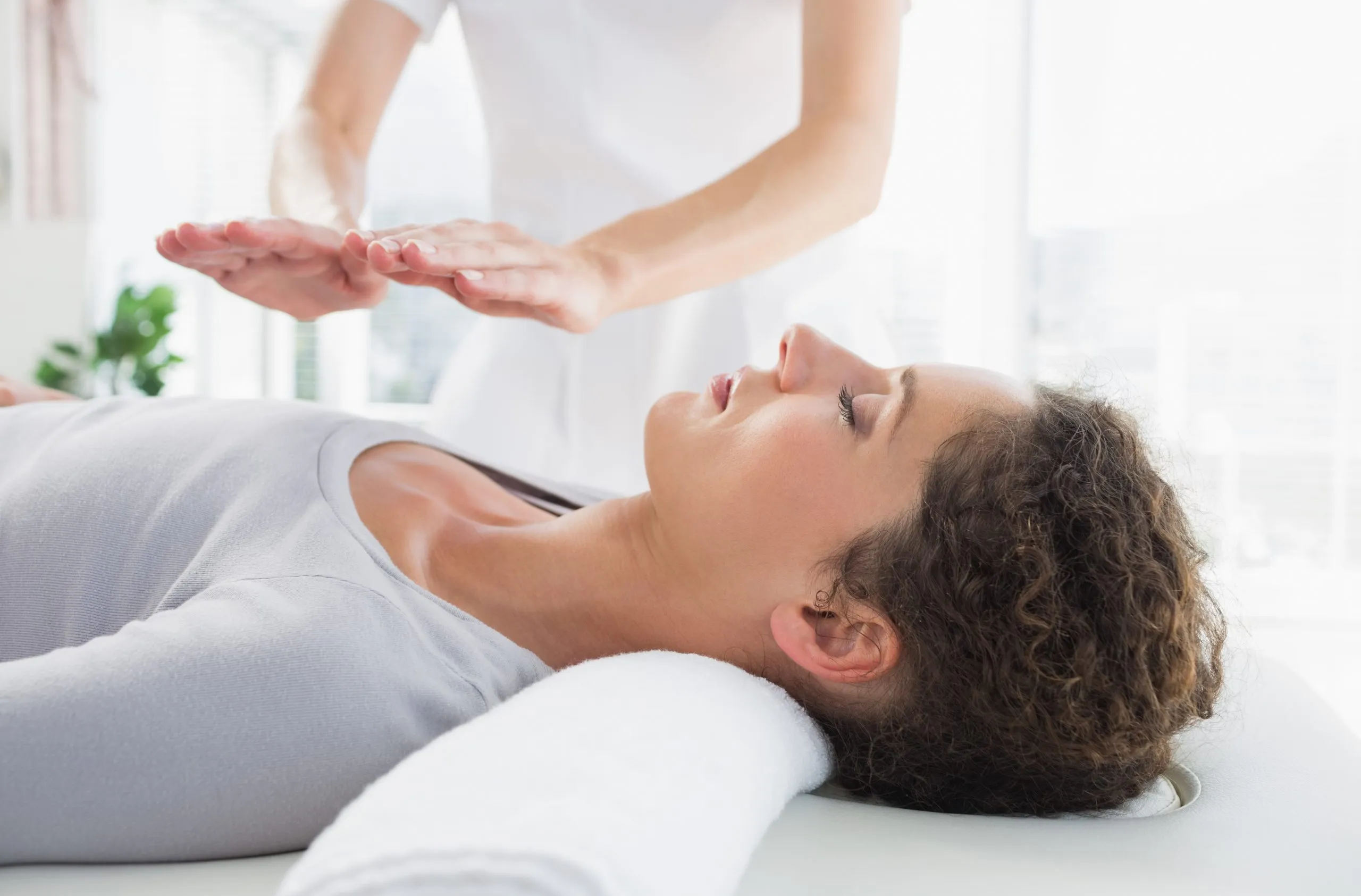 A client lying fully clothed and relaxed while receiving a Reiki treatment
